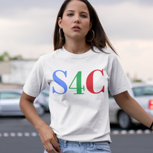 Load image into Gallery viewer, A woman wearing a white graphic t-shirt with 'S4C' printed in green, blue, and red, paired with ripped light-wash jeans, standing in an outdoor parking lot under a cloudy sky.
